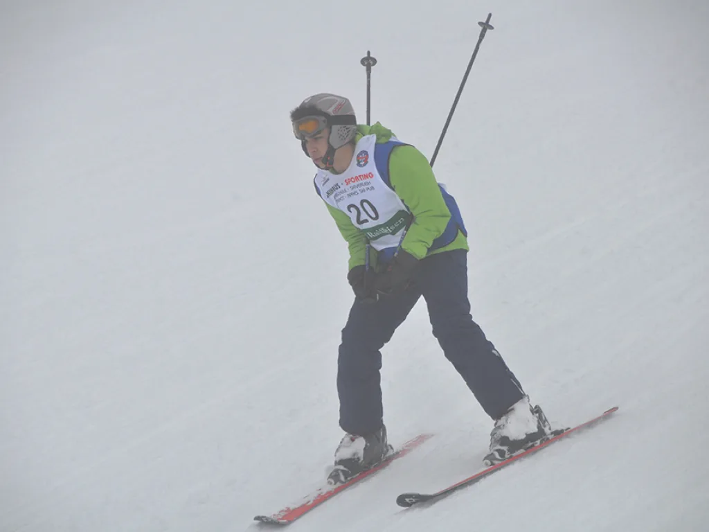 Skifahrer mit Startnummer 20 in tiefer Hocke.
